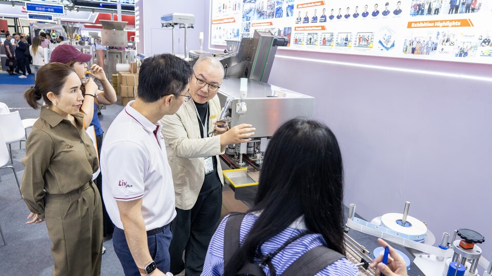 Visitors observe the live operation of the 16-lane gummy counting machine line