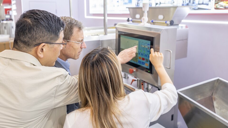 Showing how simple machine operation can be. Our team points to the touch screen of vision counting machine